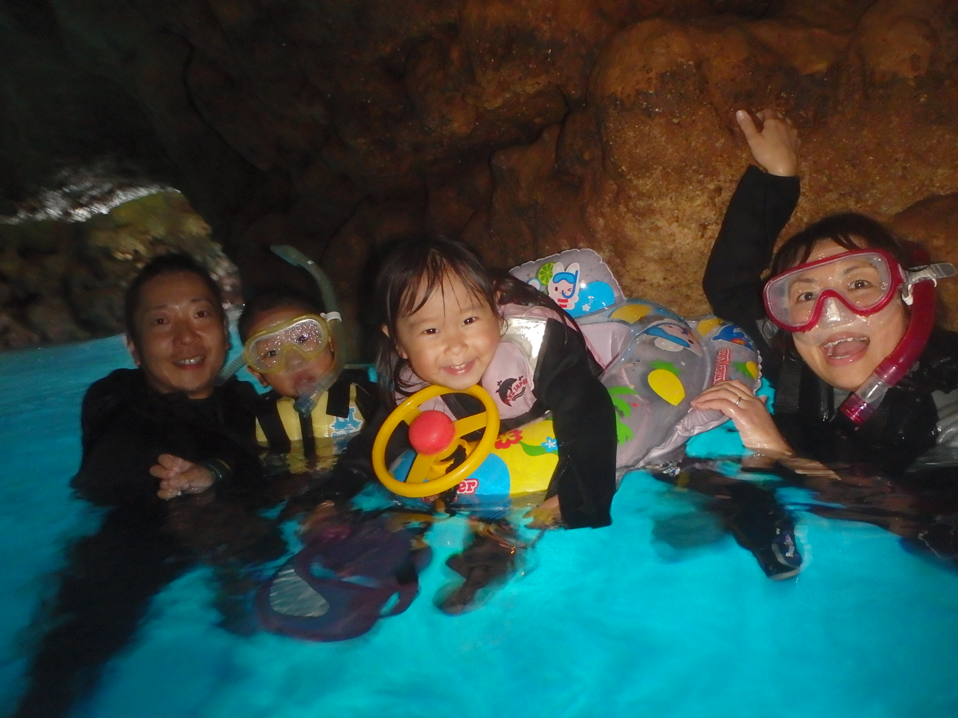 沖縄の青の洞窟でシュノーケリングツアーに参加する親子