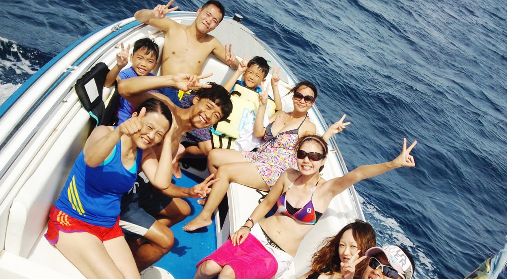 沖縄の海でパラセーリングをしに船に乗るグループ