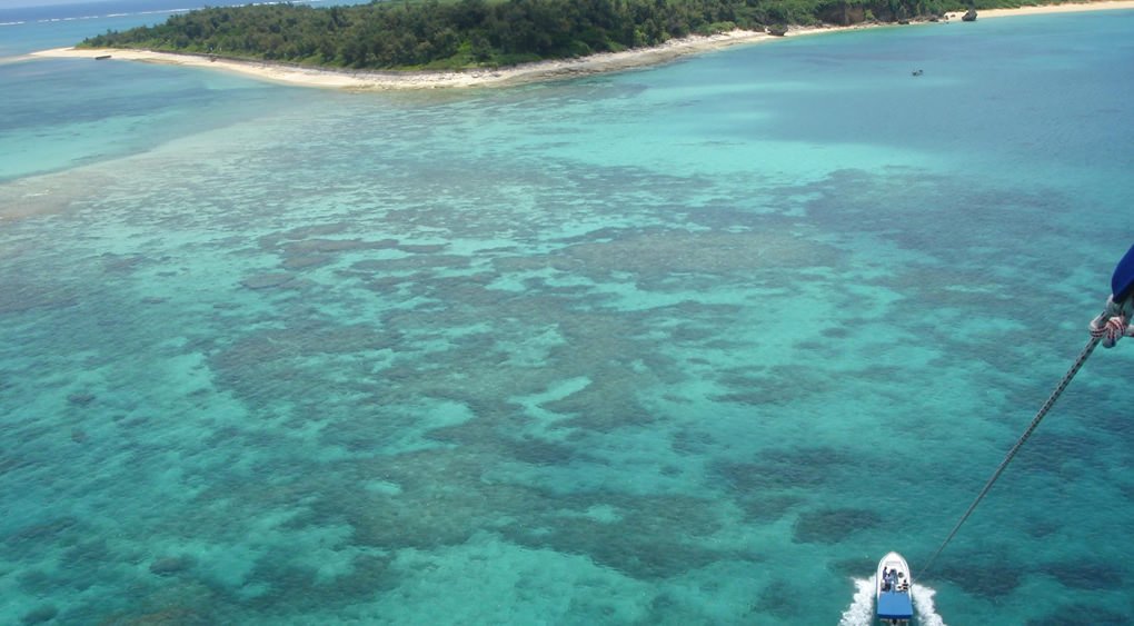沖縄の海でパラセーリングしながら見る海は青い
