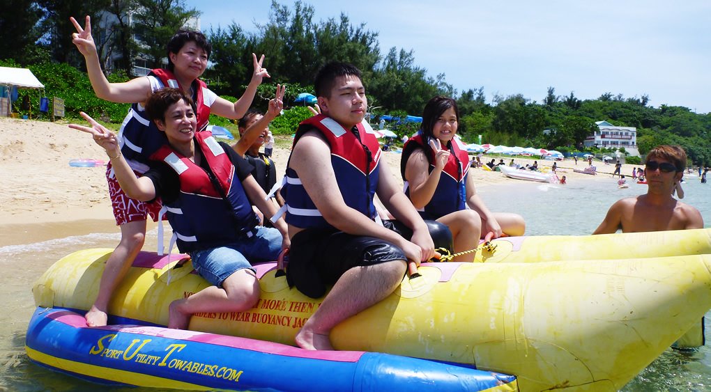 沖縄のうるま市でバナナボートに乗るグループ