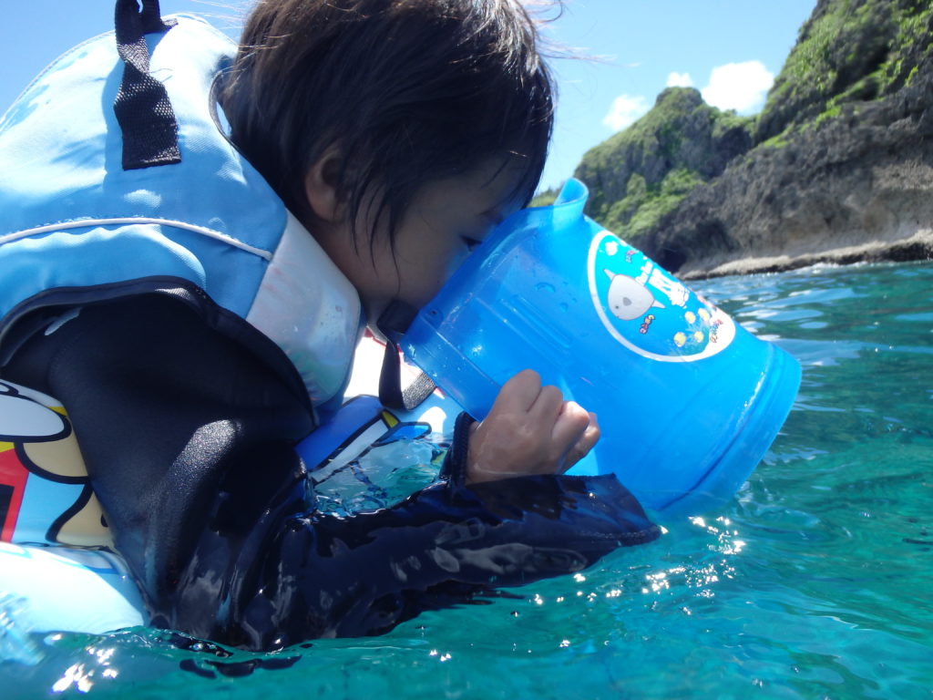 沖縄の青の洞窟で海の中をのぞく子ども