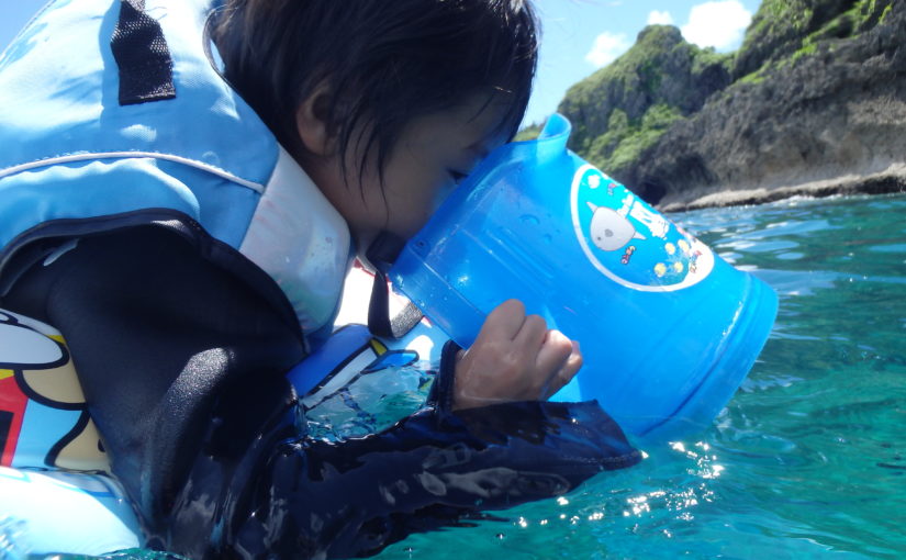 沖縄の青の洞窟で海の中をのぞく子ども