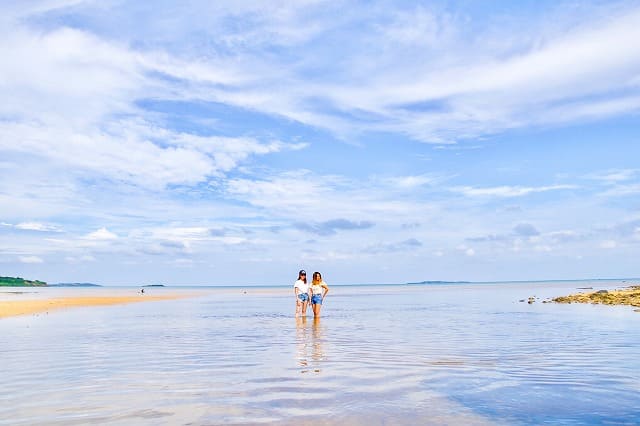 朝の海でポーズする女性