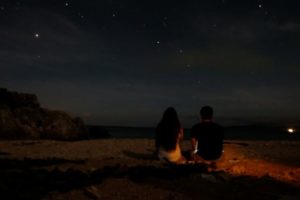 宮古島のビーチで星空を鑑賞するカップル