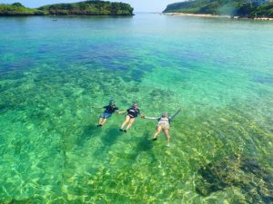 西表島の星砂海岸でシュノーケリングするグループ