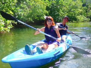 西表島のマングローブ川でカヌーをするカップル
