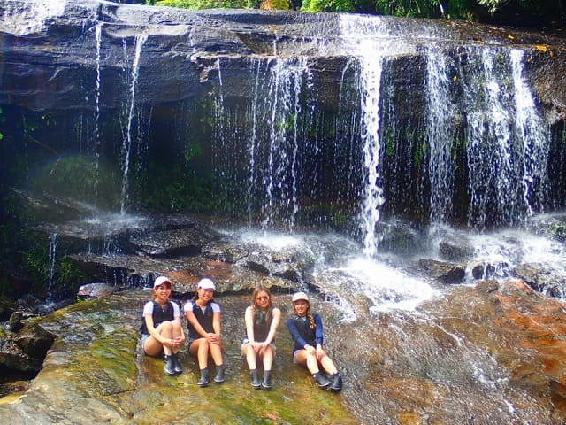 滝の前で女性たちが座る