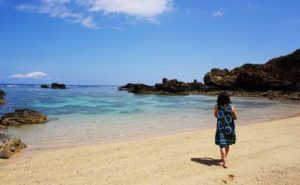 西表島のビーチを散策する女性