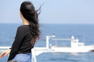 絶景スポットから海を眺める女性