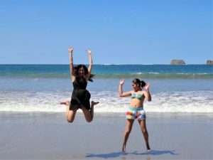 西表島のビーチでジャンプする女性