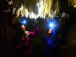 西表島の秘境地で鍾乳洞探検する女性たち