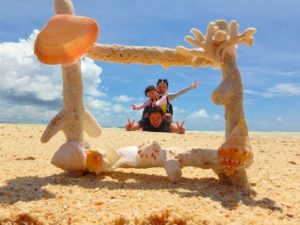 小浜島のビーチで家族旅行の記念撮影