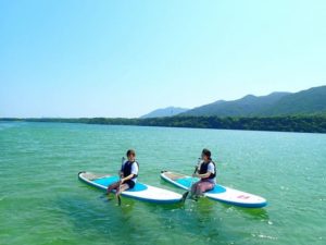 5月の石垣島でのSUPクルージングをする女性