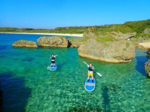 6月の時期の宮古島の海とサップを体験する女性