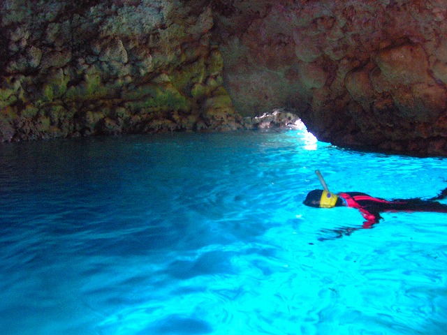 青く輝く洞窟内でのボートシュノーケル