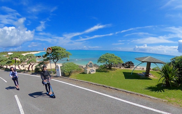 女子旅で爽快にキックボードに乗る女性