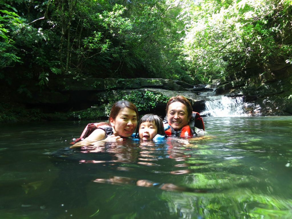 マイラの滝の滝つぼで水浴びをする家族